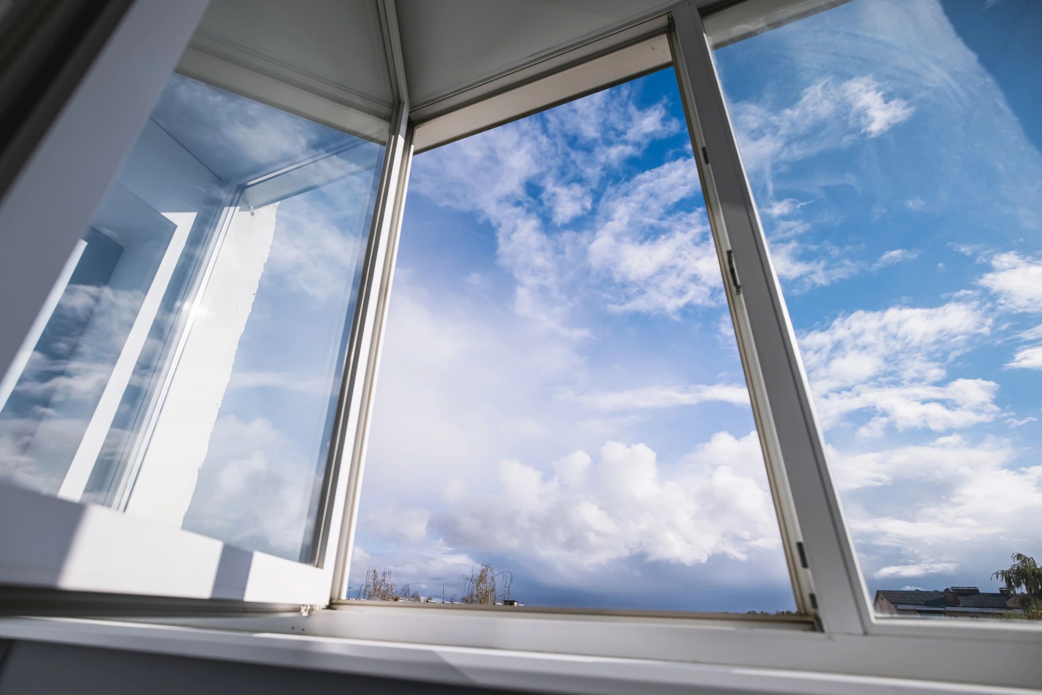 Open casement window with blue sky and clouds (natural light)