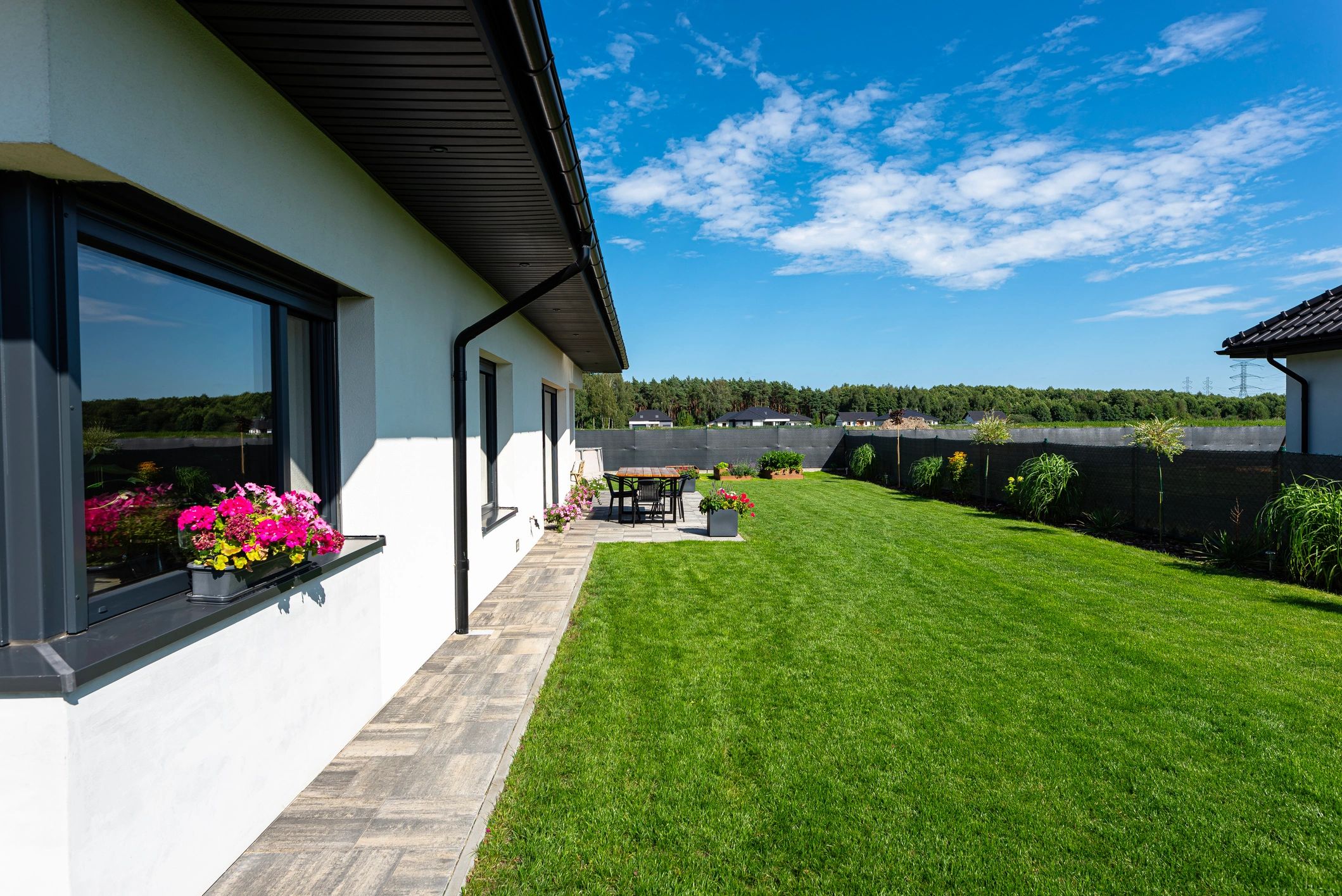 Residential home exterior with landscaped yard and covered outdoor area