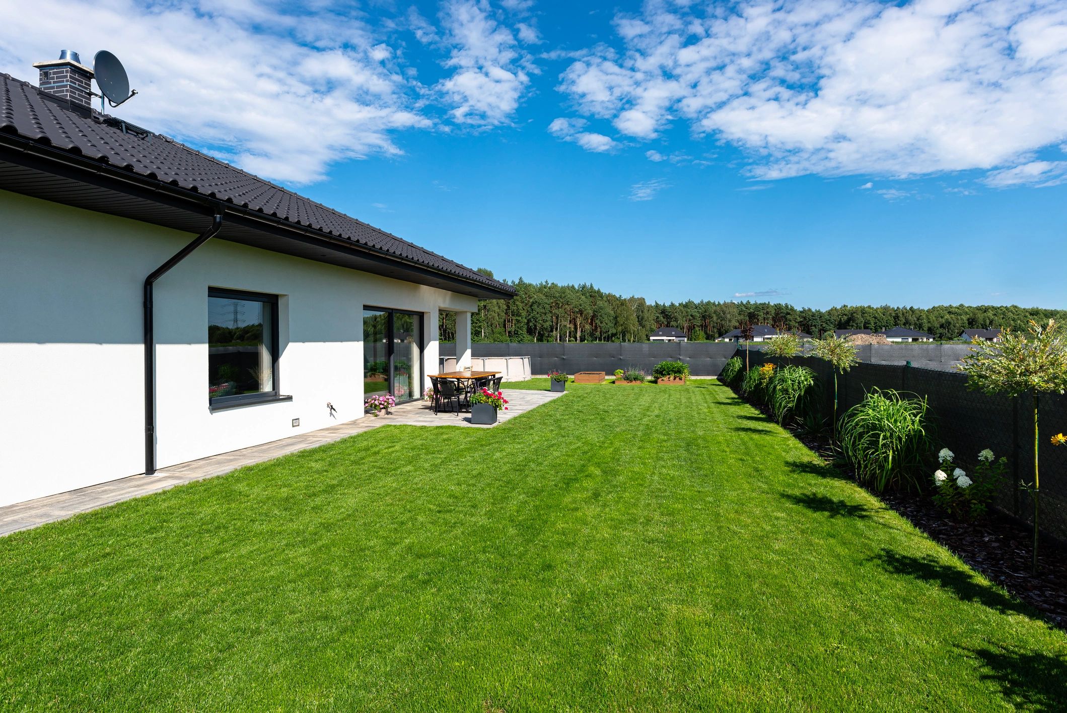 Backyard deck and lawn beside a home