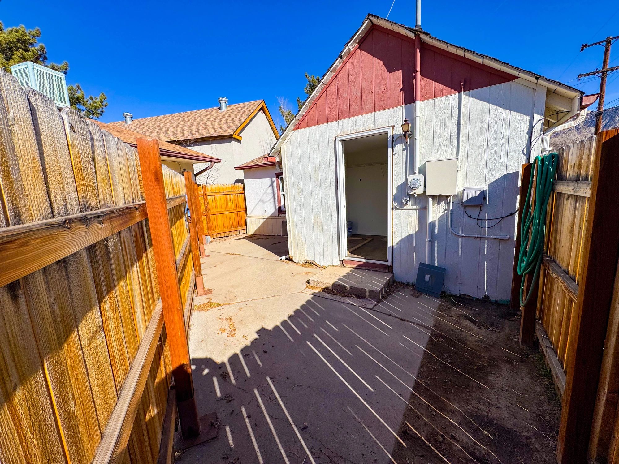 Rear entry walkway and fenced residential exterior