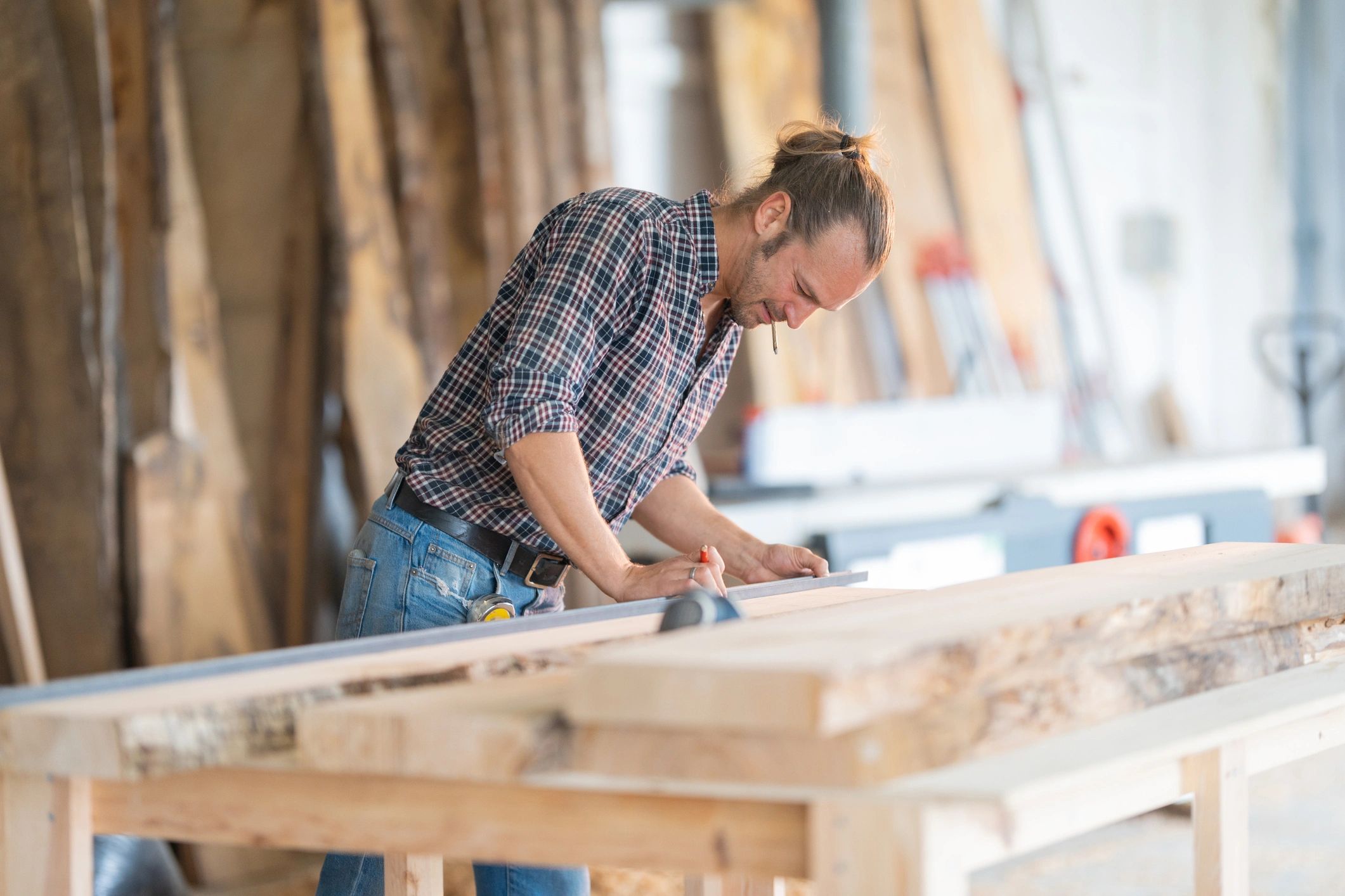 Craftsman measuring wood with precision in a workshop